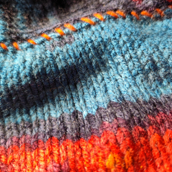 All Four details (2) Close-up of blue, charcoal and orange knitted texture