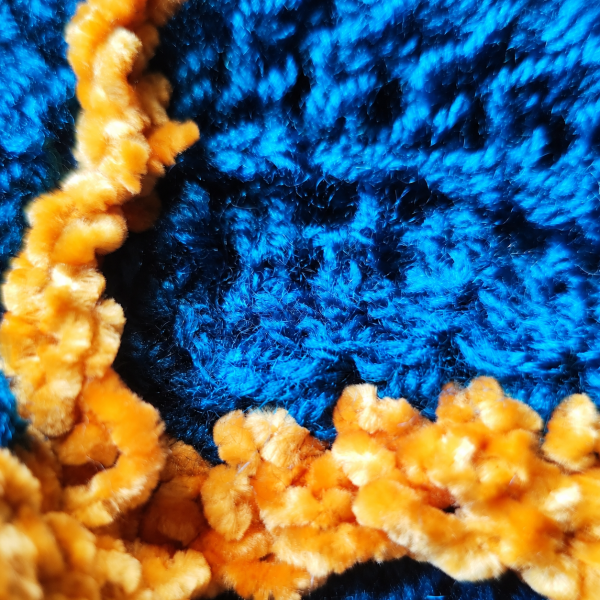 Just Because details Close-up of turquoise openwork knit and textured yellow trim
